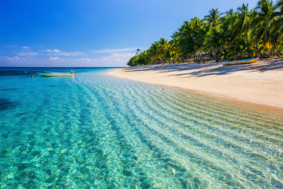 The shore of an island in Fiji with tropical water colors in shades of blue.